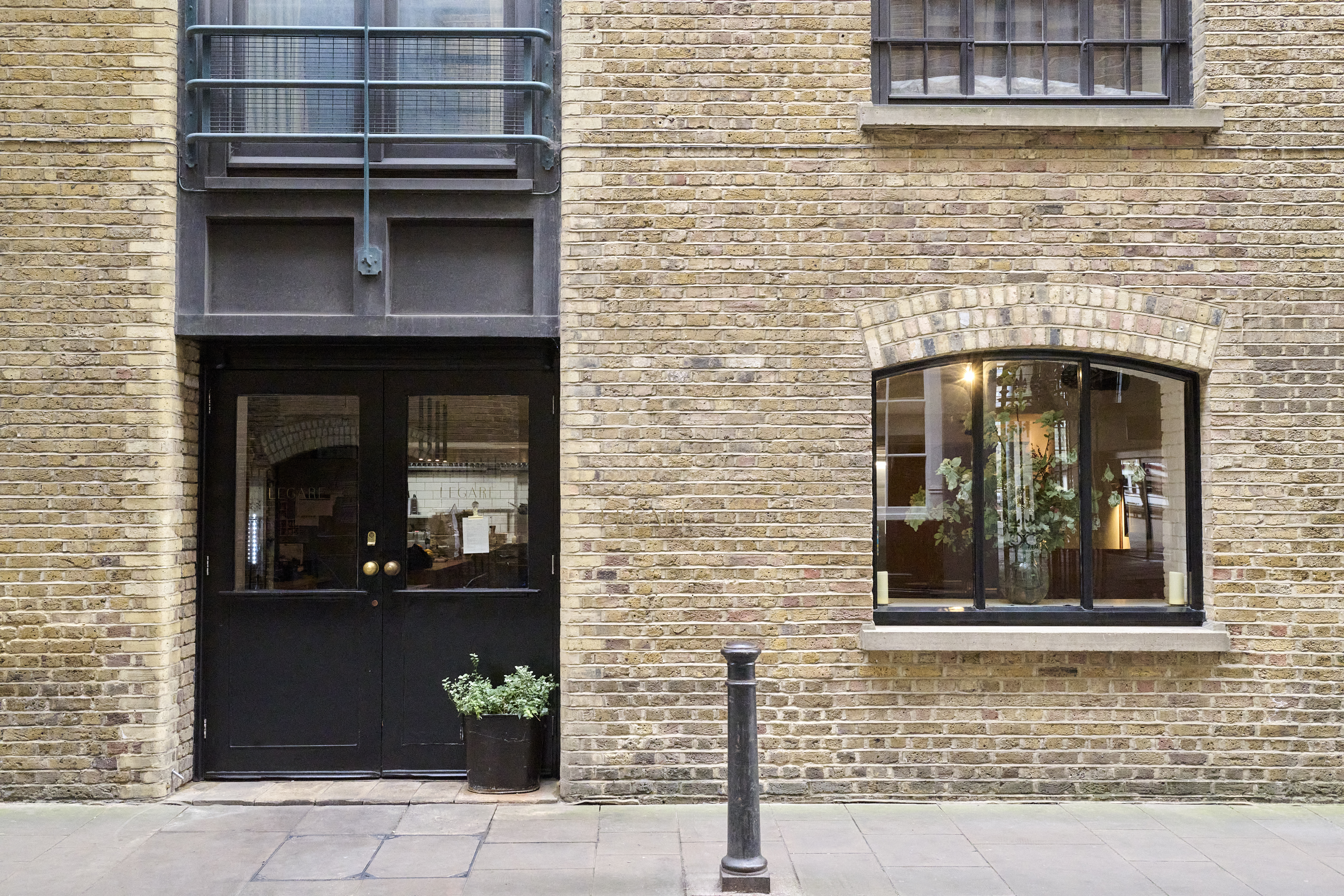 London Square Bermondsey exterior showing a red brick building with arched windows and a black door